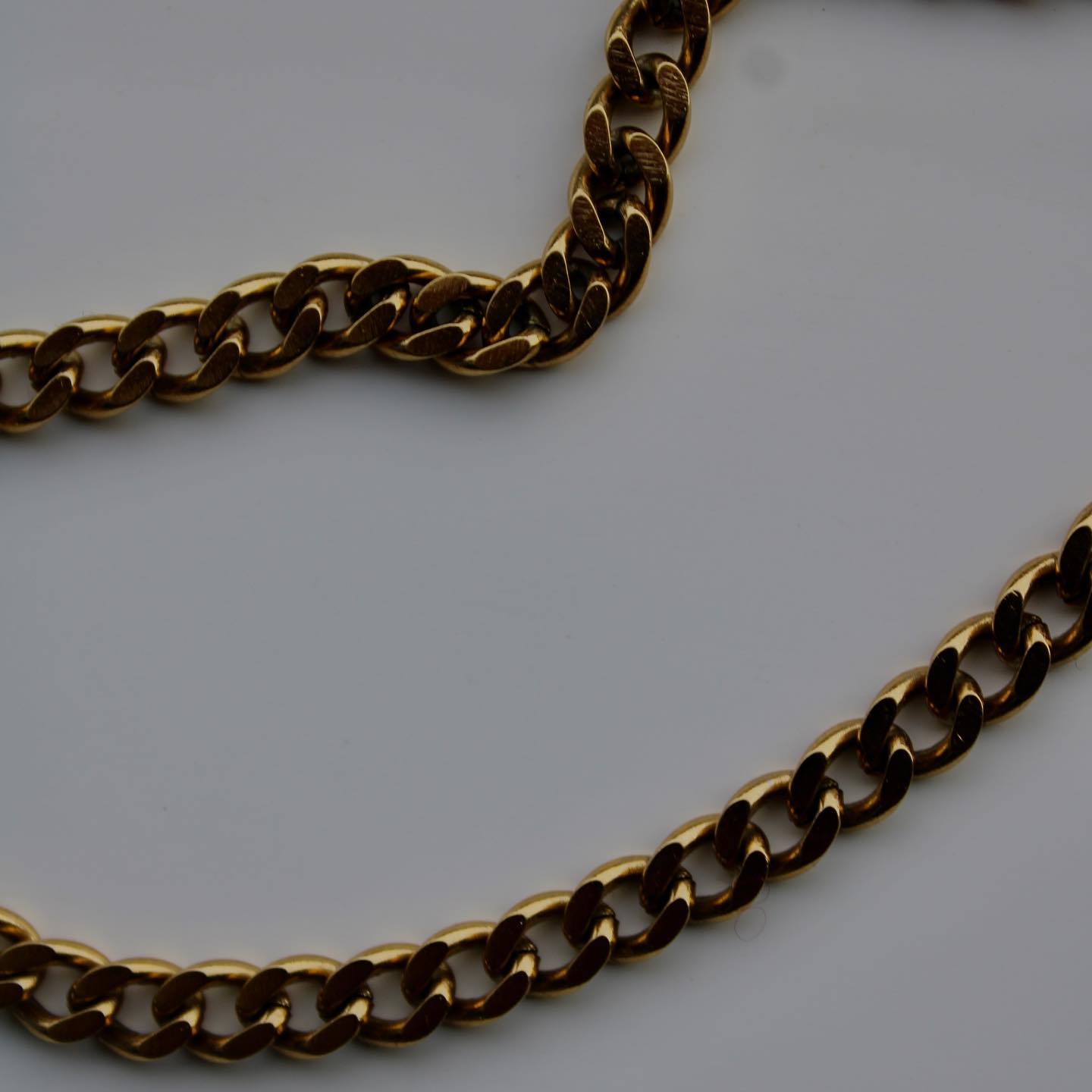 A gold curb chain necklace on fabric